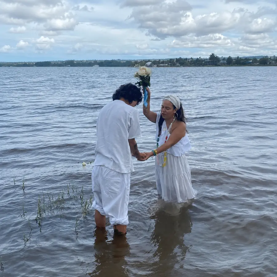 Bénédiction dans l’eau, personnes vêtues de blanc au bord d’un lac