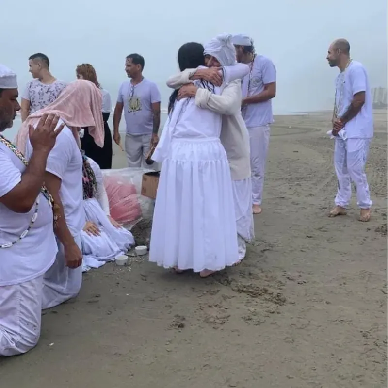 Cérémonie spirituelle sur la plage, participants vêtus de blanc